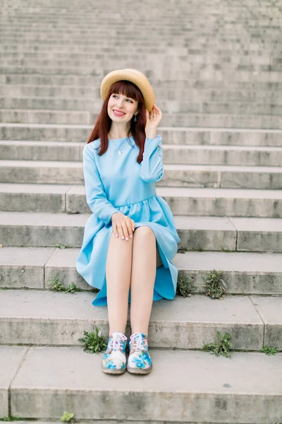 Image de belle femme élégante en robe bleue assise sur les escaliers de la rue dans la vieille ville européenne . — Photo
