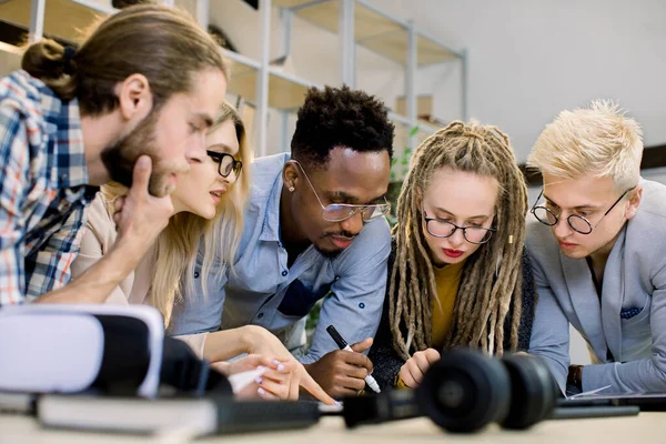 Des collègues multiethniques concentrés se réunissent dans la salle de bureau pour réfléchir et discuter des statistiques financières et du projet commun. Réunion de bureau, concept de travail d'équipe — Photo