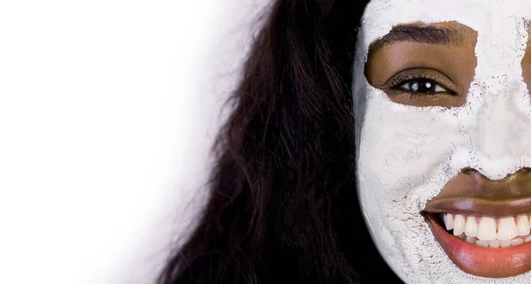 Retrato de perto recortado de menina africana muito sorridente com máscara de levantamento antienvelhecimento aplicada em seu rosto, isolado em fundo branco. Beleza, cuidados com a pele, conceito de cosméticos naturais — Fotografia de Stock