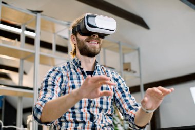 İş, teknoloji, artırılmış ve sanal gerçeklik kavramı. Neşeli Kafkasyalı hippi sakallı iş adamı VR deneyimi yaşıyor ve kulaklığı ayarlıyor.