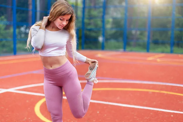 Jonge fitness vrouw loper stretching benen voor run op de stad — Stockfoto