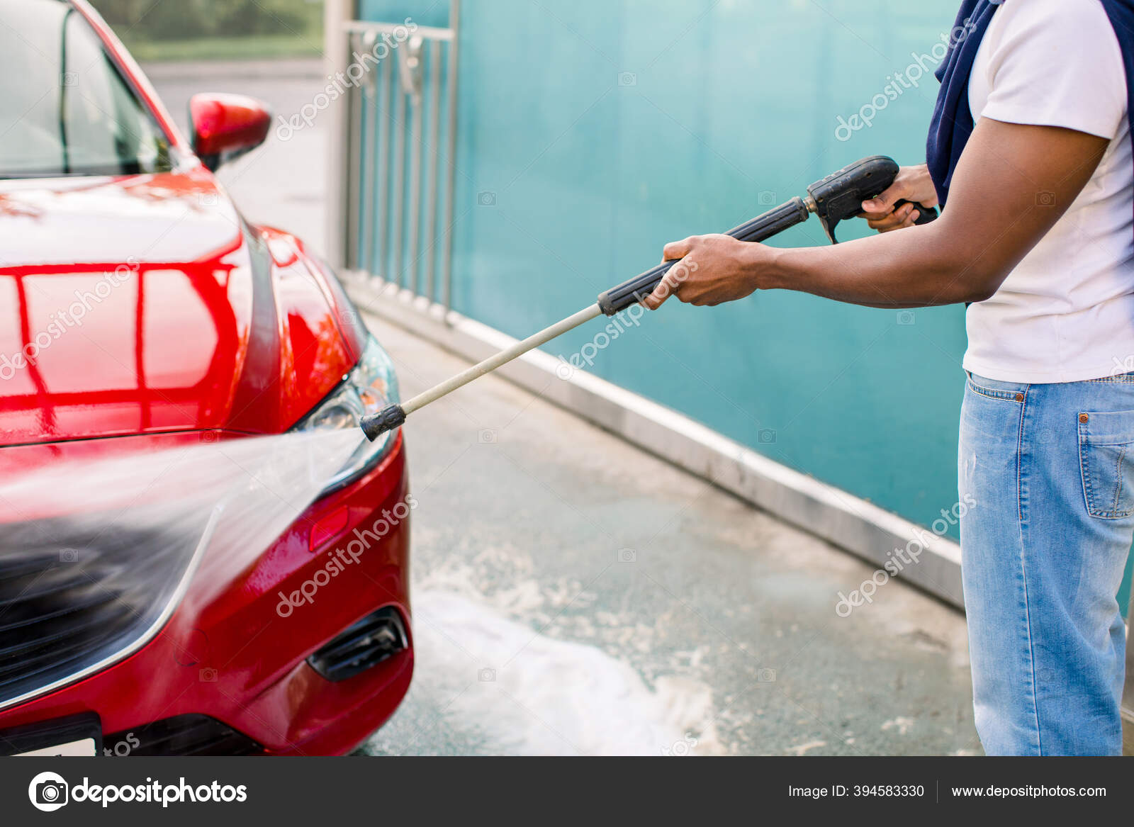 Disparo horizontal de hombre caucásico con pulverizador de alta presión con  espuma de limpieza en su coche negro en el servicio de lavado de coches al  aire libre. concepto de coche limpio