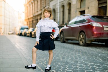 Ukrayna, Lviv 'deki eski şehir sokağında güzel sarışın bir kızın tam boy portresi. Şehirde güzel bir kızın moda tasviri.