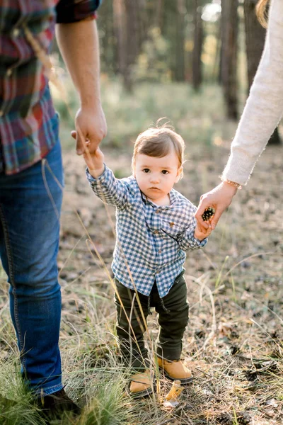 Sonbahar parkında ya da ormanda oğluyla el ele tutuşan genç ebeveynlerin görüntüsü. Sonbahar açık hava portresi. Aile, ebeveynlik ve insan konsepti — Stok fotoğraf