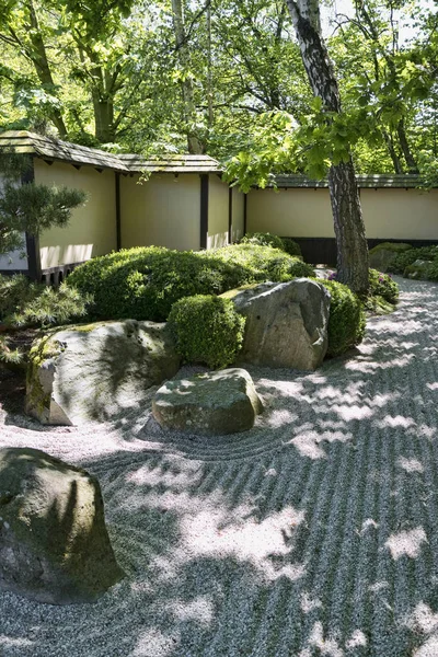 Part of Japanese garden with ocean in the sand