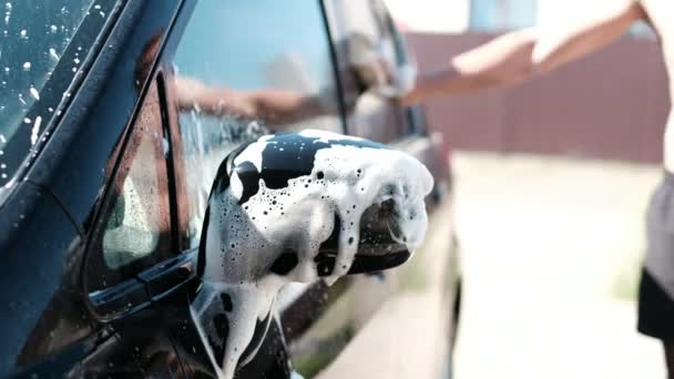 男が泡で黒の車を洗っています — ストック動画