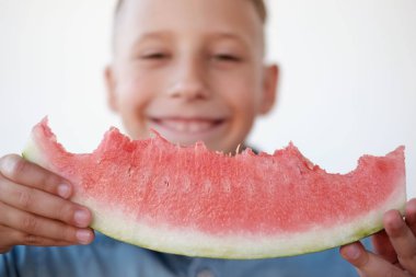 Mutlu çocuk karpuz yeme ve beyaz arka plan gülümseyen