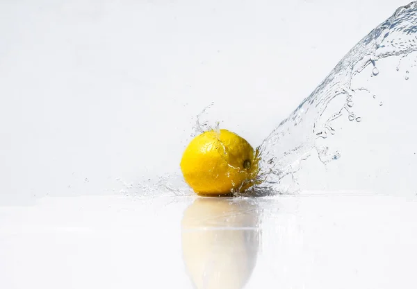 Water splash on yellow lemon on white background