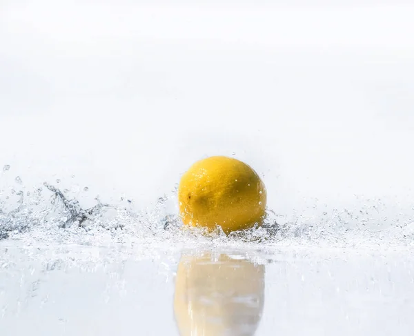Water splash on yellow lemon on white background