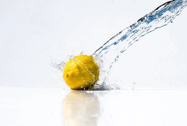 Water splash with yellow lemon on white background