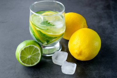 Siyah arka planda taze limonata için sarı limon ve limon