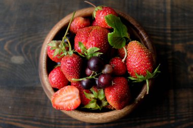 Karanlık arka planda sulu çilek ile Bowl