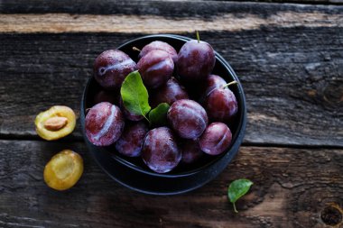 Koyu ahşap masa arka planda taze mor erik