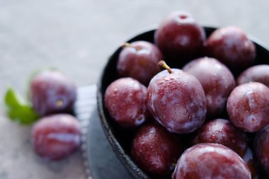 Koyu ahşap masa arka planda taze mor erik