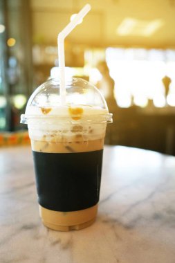 Kafede gri zemin masada plastik bardak soğuk kahve. (yumuşak odak)