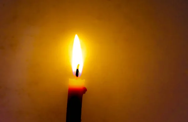 Палаюча свічка в темряві з темним тлом . — стокове фото