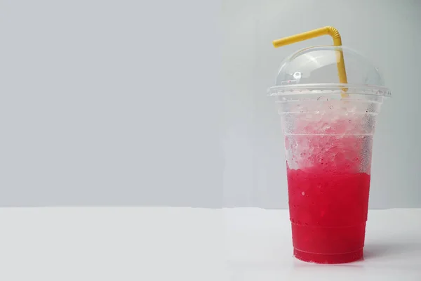 Napój Bezalkoholowy Lodem Plastikowej Szklance Białym Stole Czerwona Woda Soda — Zdjęcie stockowe