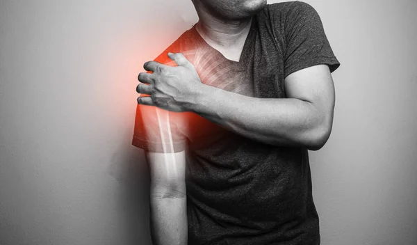 Close up Shoulder and clavicle fracture pain in a man, Young man holding his shoulder in pain  Shoulder  inflammation symptoms medical healthcare concept