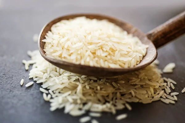 Raw rice in a wooden spoon. Healthy food. Diet, dieting concept. Seeds of white basmati rice