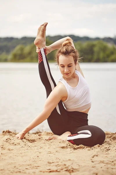 Woman doing yoga on a lake. Flexibility, activity, yoga, pilates, health concept