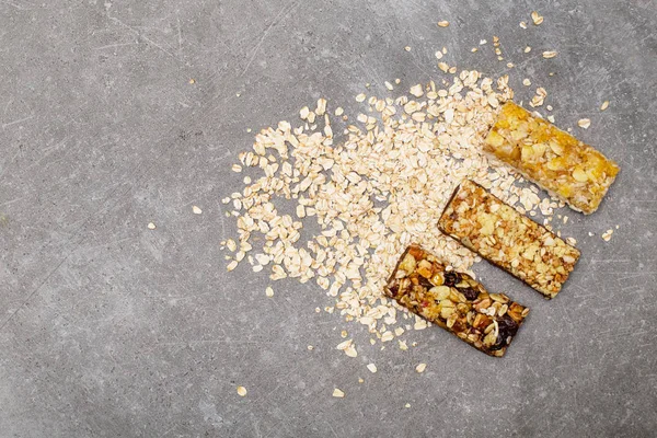 Granola bar top view. Healthy organic sweet dessert snack. Cereal granola bar with nuts, fruit and berries on grey stone table