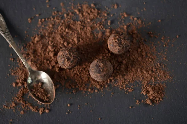 Chocolate candy truffle with cocoa powder on a grey background