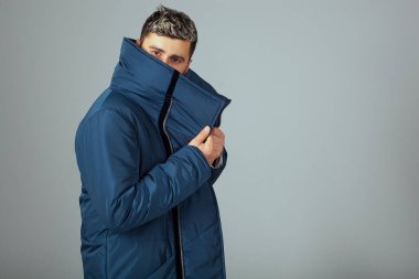 Avrupalı görünümlü bir adama kışlık kalın bir ceket. Yüksek yakalı bir adam çerçeveye bakan genç bir adamın yüzünü kapatır. Sıcak, sakin ve güvende hissediyorum.