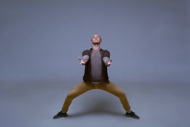 Örnek erkek testleri. Erkek model gri arka planda dinamik bir pozda. Resimde metin için bir yer var. Dans ederken erkeklerin esnekliği