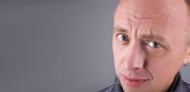 Erkekler için model testleri. Mavi gözlü yakın portre. Çerçeveye soru ve iğneleme ile bakıyor. Emin misin diye soruyor.