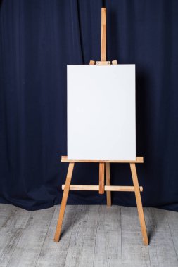 Mavi perdelerin arka planındaki sehpa beyaz bir lamine üzerinde duruyor.