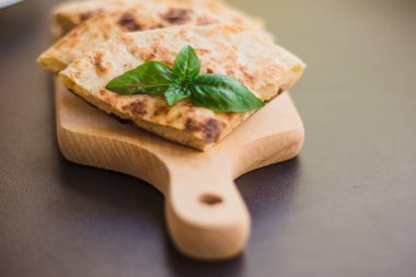 Patatesli tortilla, pide, chapati, fesleğen yaprağı ile süslenmiş, siyah arka planda, doğu yemekleri.