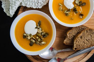 Balkabağı çorbası krem, tohum, grunge siyah arka plan üzerinde ekmek. Üstten görünüm