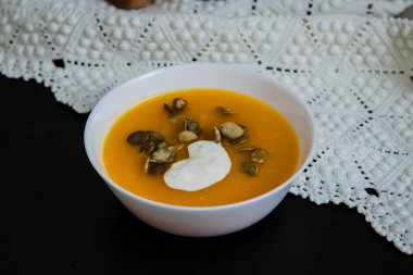 Balkabağı çorbası krem, tohum, grunge siyah arka plan üzerinde ekmek. Üstten görünüm