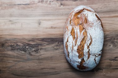 Tahta masada taze ekmek ve metnin için yer var. Ahşap masada taze pişmiş geleneksel ekmek..