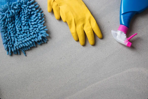 Cleaning products. Home cleaning concept. Top view. Place for typography and logo. on a marble background yellow gloves