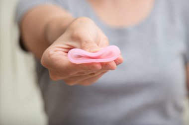 Kadınların el katlama regl bardağını kapatarak nasıl kullanılacağını göster. Kadın sağlığı konsepti, sıfır atık alternatif