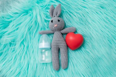 Bebek besleme konsepti. Oyuncak ayı tavşan, küçük şişenin yanında yiyecek üst görüş alanı yazılı, oyuncak bebek şişesi.