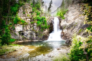 Çalışan kartal buzul ulus parkında düşüyor. Çalışan kartal Falls Amskapi-Pikuni Kızılderili insanlar bir kadın savaşçı sonra adlandırılmıştır. Bir çift su düşüş bu görüntüde akan her iki Şelalesi ile bu.