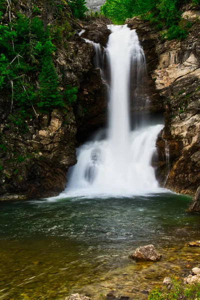 Running Eagle Falls in Glacier Nation Park.  Running Eagle Falls is named after a female warrior of the Amskapi-Pikuni Native American people.  This is a double water fall with both falls flowing in this image.