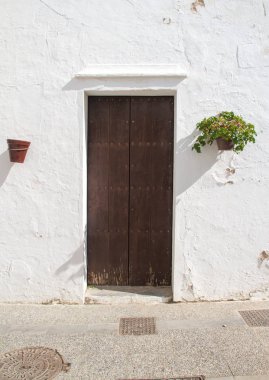 Doğrudan güneş ışığı altında beyaz sıva duvar bir İspanyol tarzı kapı.
