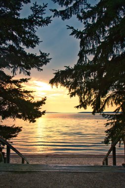 Merdivenlerden aşağı beach Prince Albert Kanada Milli Parkı Waskesiu Gölü üzerinde güneş ayarı ile lider.