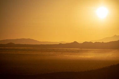 Doğal sıcak tonlar Arizona çölü dağların üzerinden yükselen güneş.