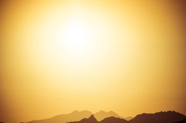 Doğal sıcak tonlar Arizona çölü dağların üzerinden yükselen güneş.