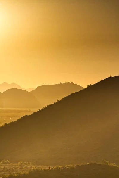 自然な温かみのある色合いとアリゾナ州の砂漠の山の上に昇る太陽 — ストック写真