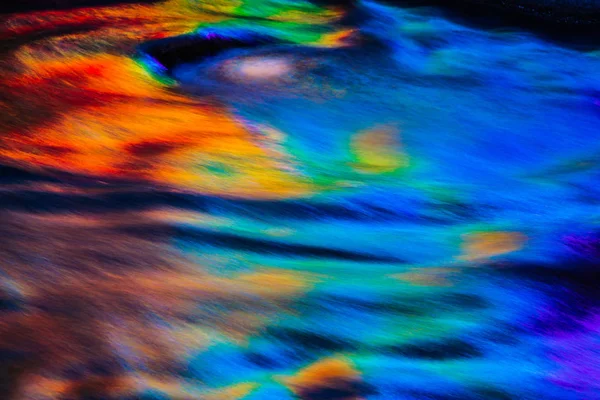 A rainbow of colors being reflecting in water — Stock Photo, Image