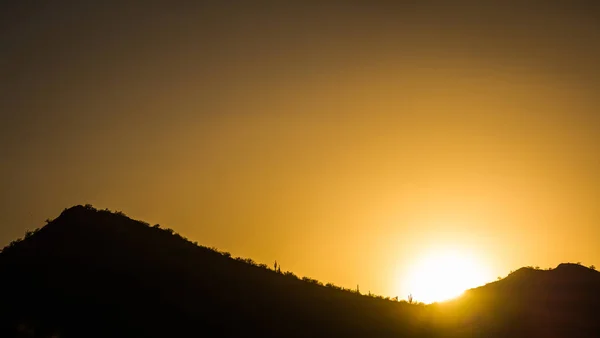 Il sole che tramonta dietro una montagna — Foto Stock