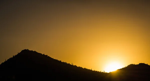 Il sole che tramonta dietro una montagna — Foto Stock