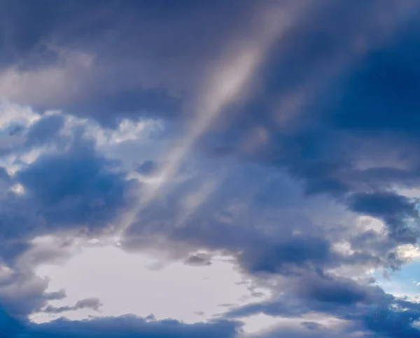 Rayos de sol irradiando bajo nubes de colores — Foto de Stock