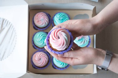 Cupcake cupcakes, flatlay bir kutu arka plan üzerinde bir kız elinde