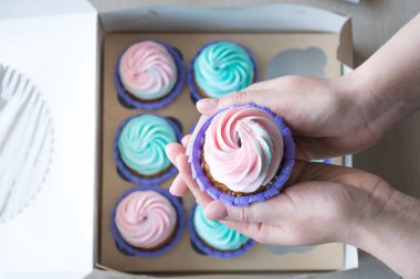 Cupcake cupcakes, flatlay bir kutu arka plan üzerinde bir kız elinde